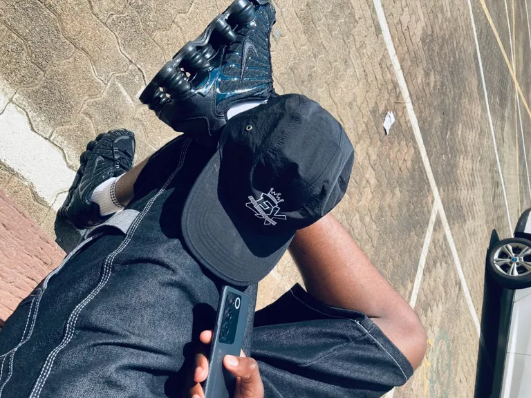 Overhead lifestyle photograph showing the Exclusive Apparel logo on a black cap